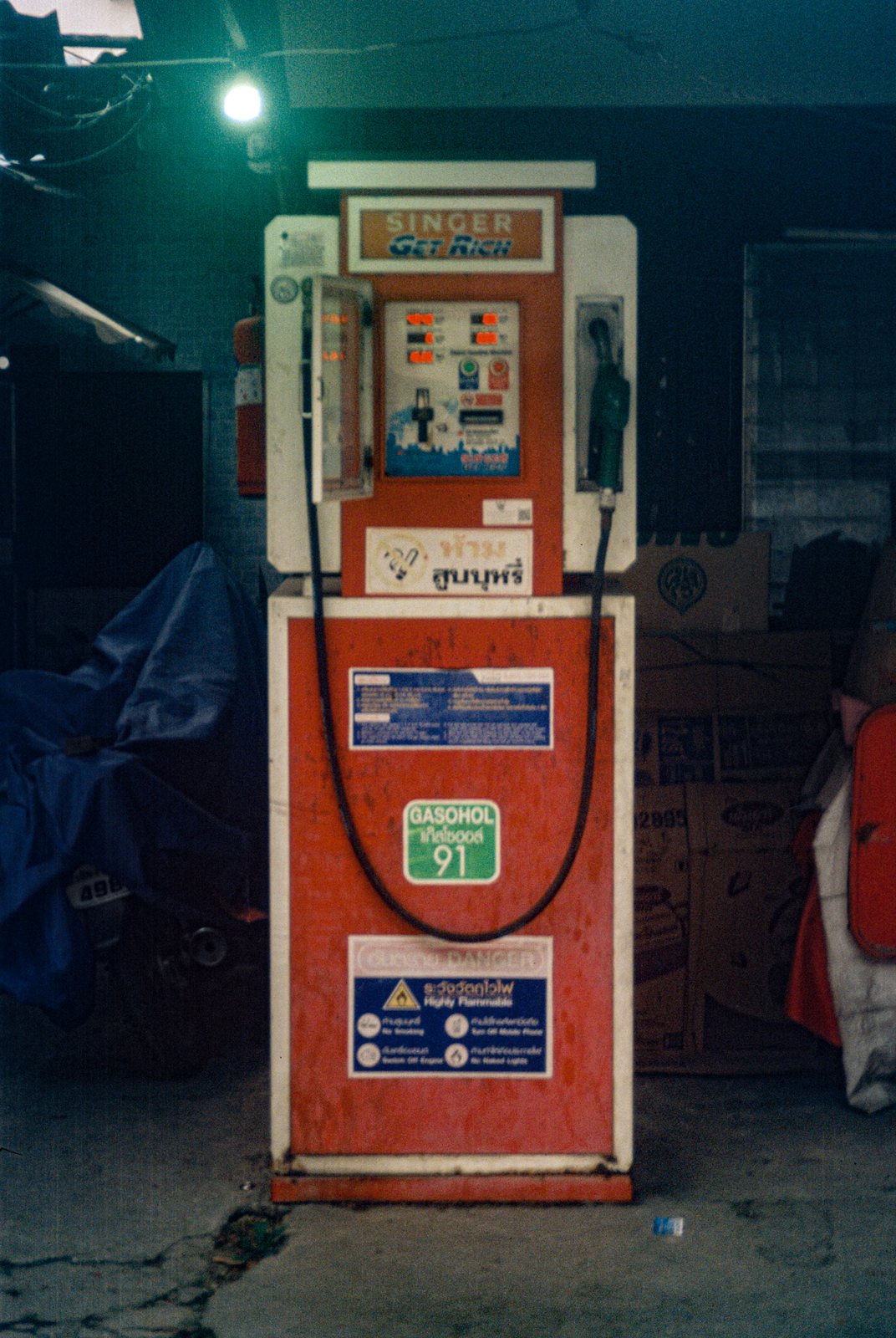 An old red petrol pump at dusk