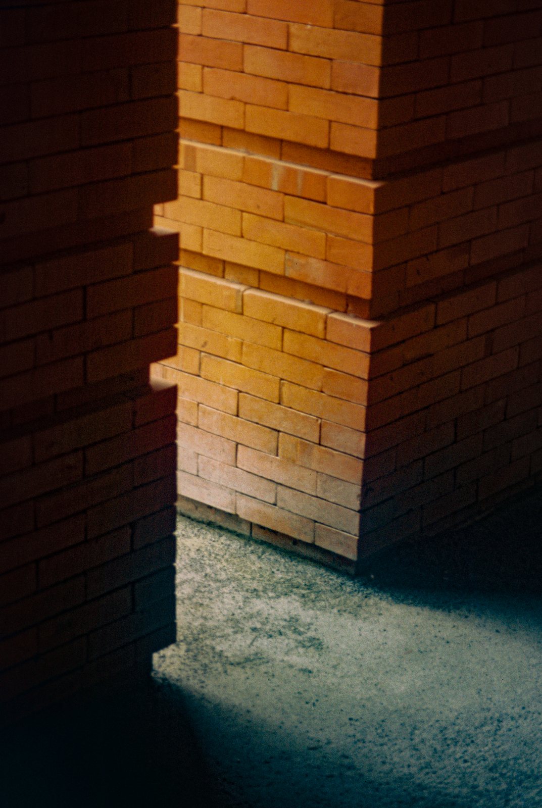 An orange brick pillar in shadow