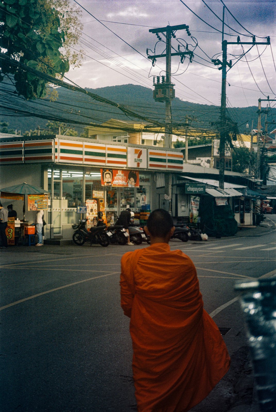 A monk crossing the road, mountains behind